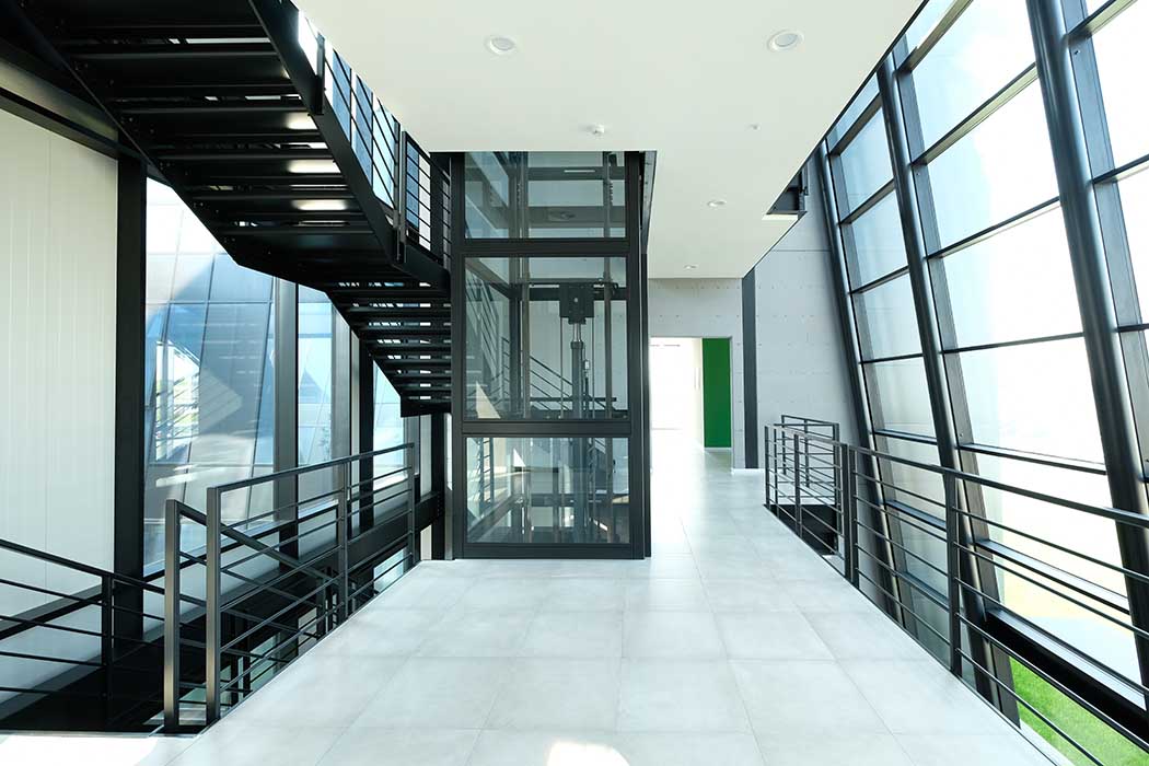 La grande vetrata inclinata dell’ingresso è sostenuta da una struttura metallica composta da montanti e traversi - vista dall'interno